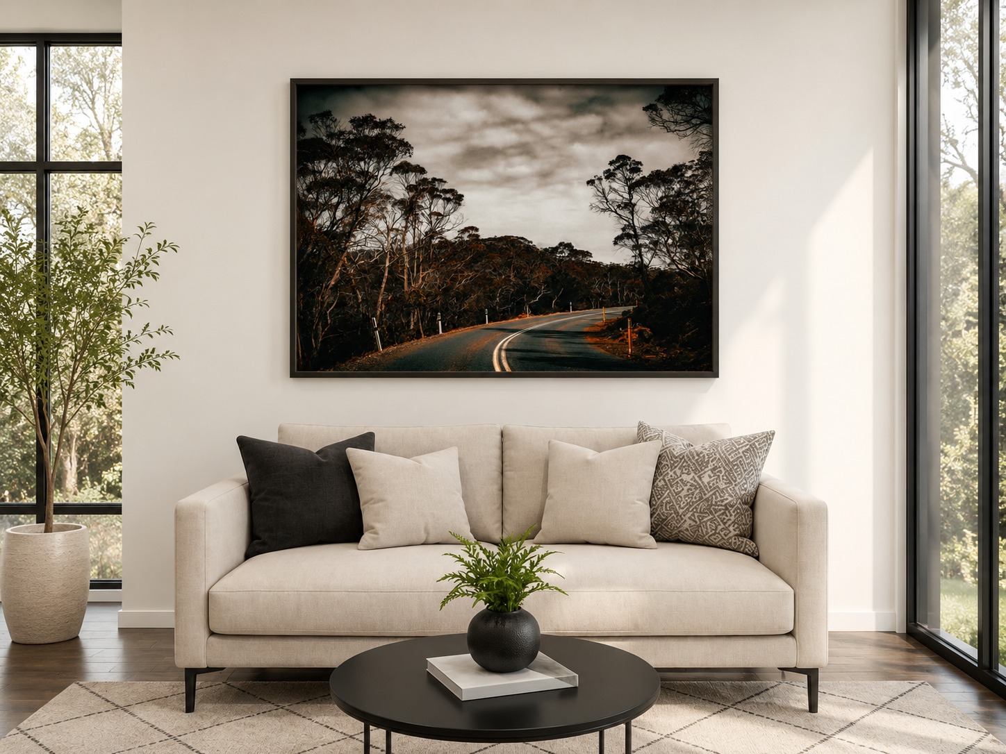 Large horizontal landscape wall art above a cream sofa in a bright living room