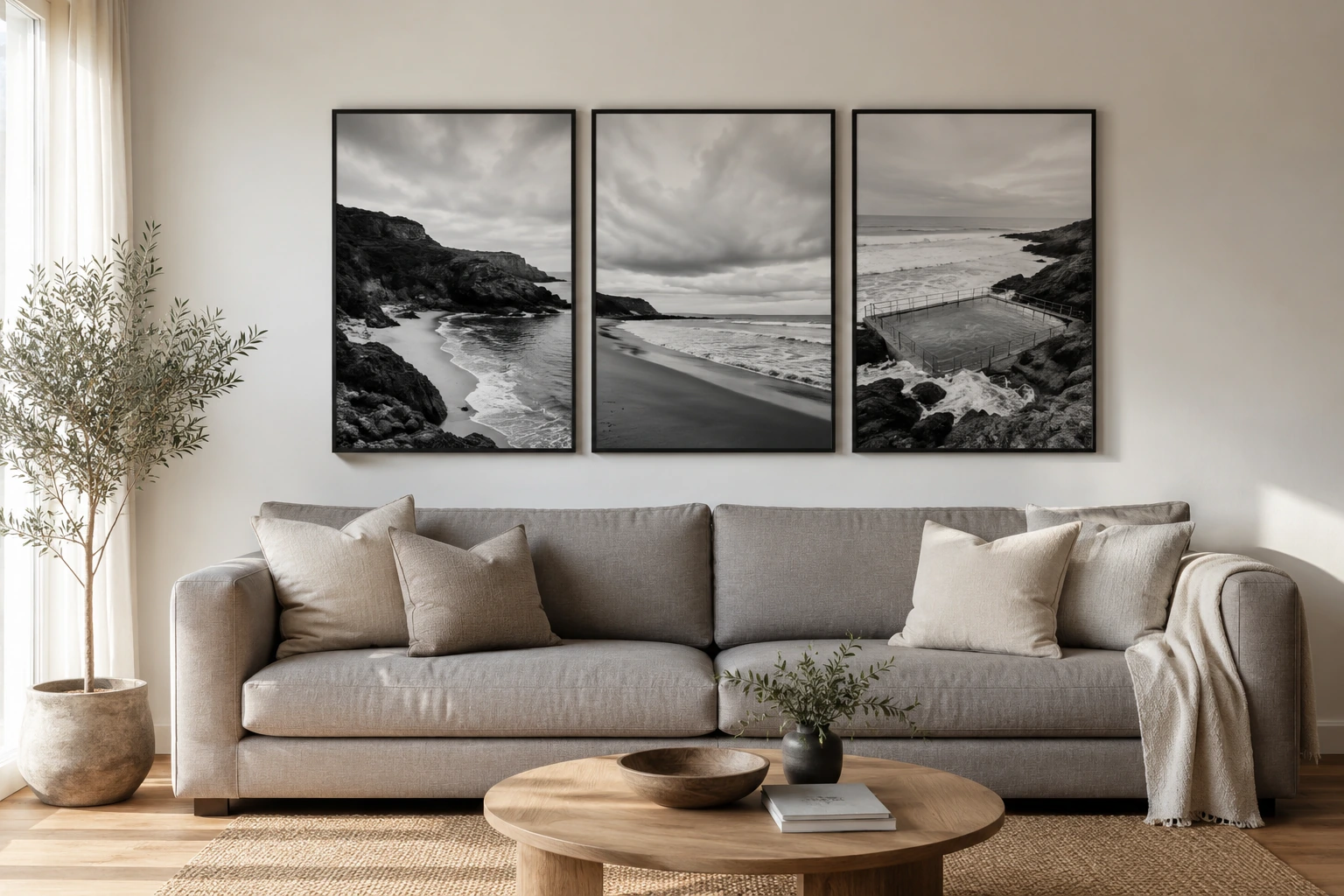 Three coordinated black and white photography prints hung with even spacing above a long sofa